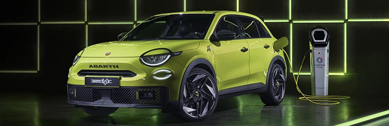 Bright yellow car next to an electric vehicle charging point.