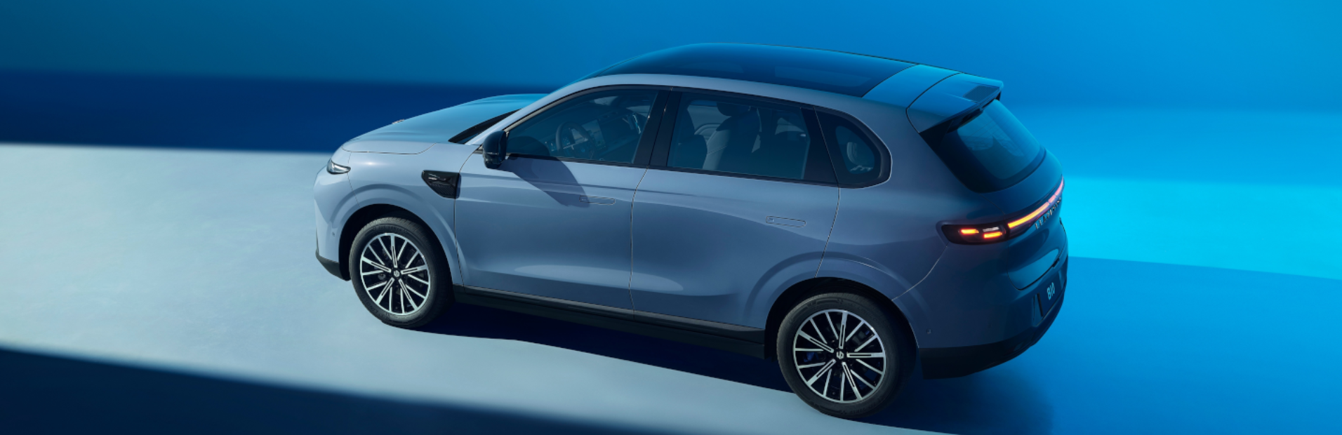 Aerial view of a silver SUV with a panoramic roof and distinctive tail lights.